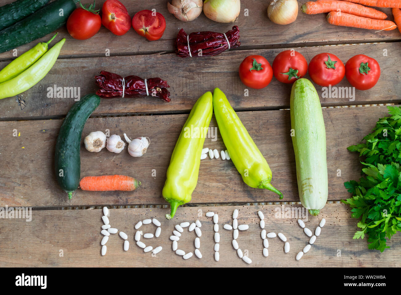 Vari ortaggi freschi dal mercato su sfondo di legno facendo segno mangiare sano. Foto Stock