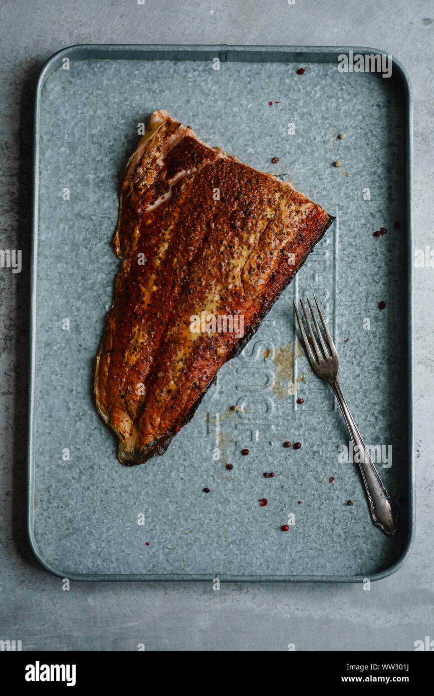 Salmone affumicato con pepe con forcella sul vassoio metallico Foto Stock