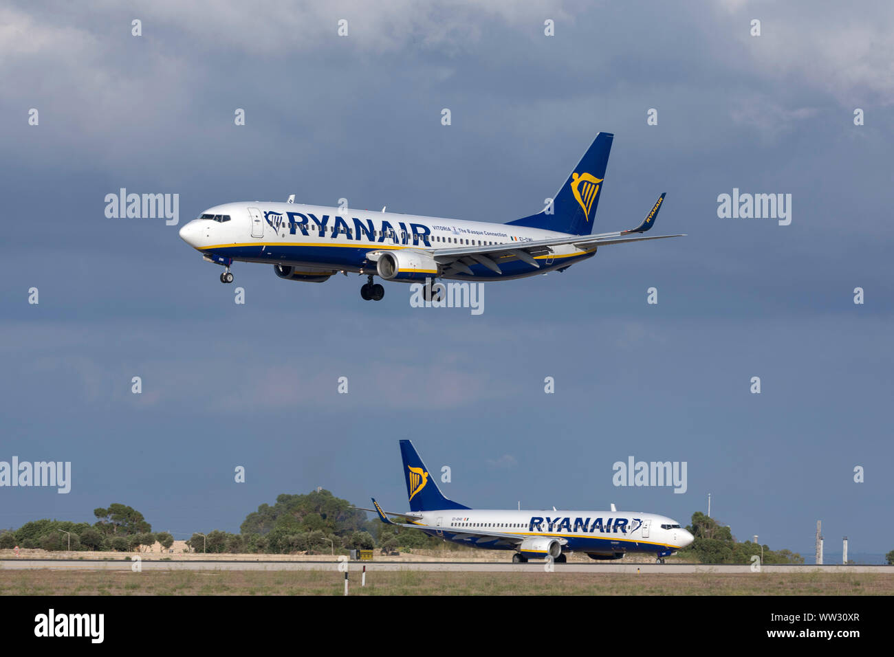Ryanair Boeing 737-8come (REG: EI-DWI) arrivando a terra mentre un altro Ryanair 737 (EI-DHG) attende su Alpha loop per il decollo. Foto Stock