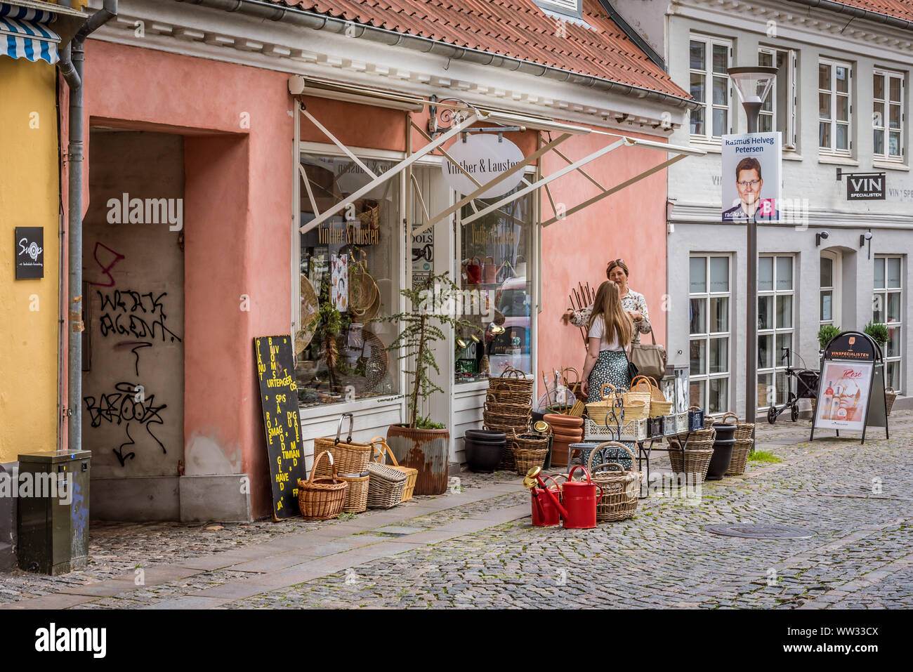 Due signore in chat al di fuori di un negozio vintage, Svendborg, Danimarca, 11 Luglio 2019 Foto Stock
