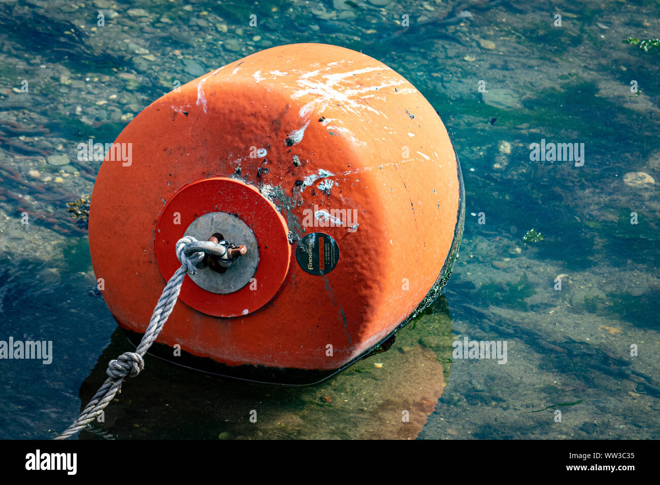 Orange Barca/boa galleggianti e corda nel porto di Looe .Devon UK Foto Stock