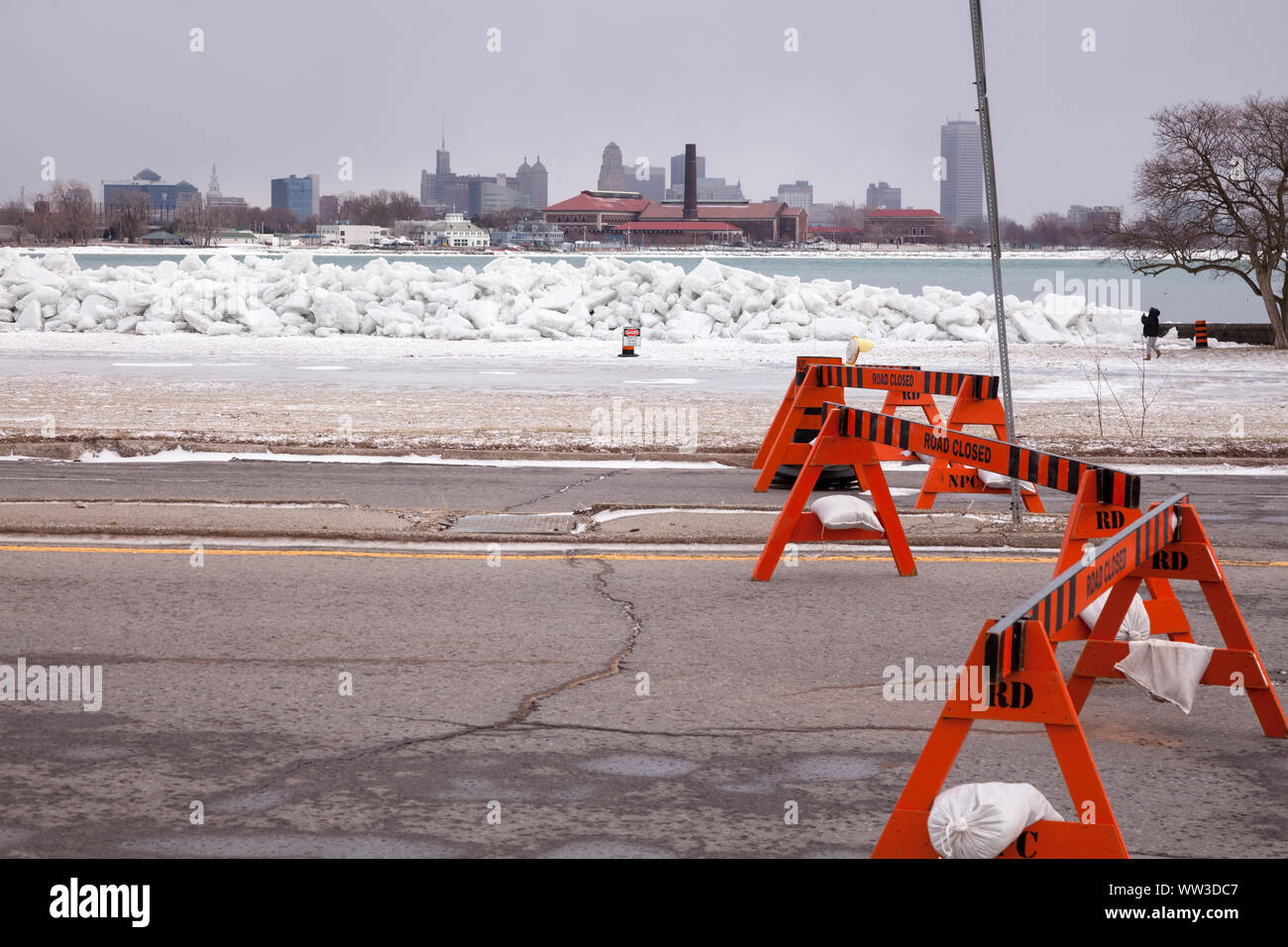 Una chiusura della strada a causa di un ice shove dove il Lago Erie incontra il fiume Niagara con la Skyline di Buffalo nella distanza di Fort Erie, Ontario, Canada. Foto Stock