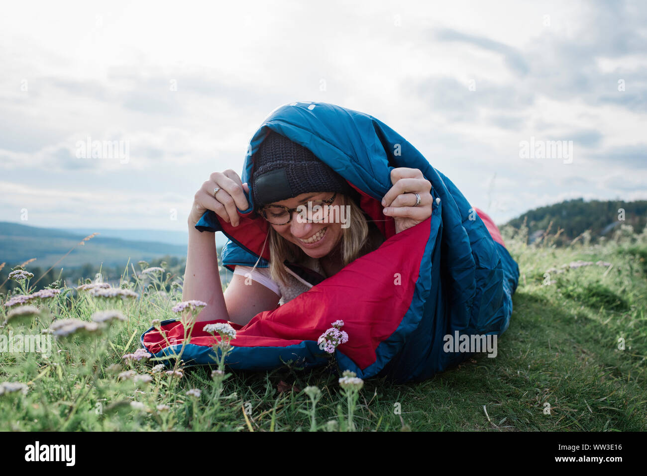 Ritratto di donna campeggio selvaggio avvolto in un sacco a pelo Foto Stock
