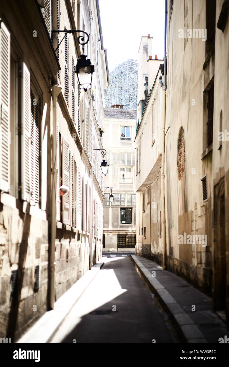 Sunny street nel centro di Parigi con un uomo guardando fuori della finestra Foto Stock