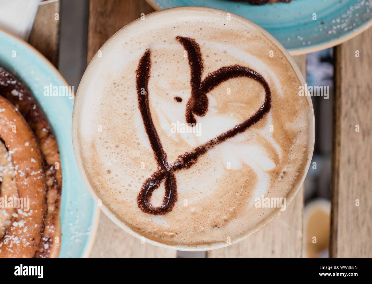 Cuore barista art caffè con dolci presso una caffetteria Foto Stock