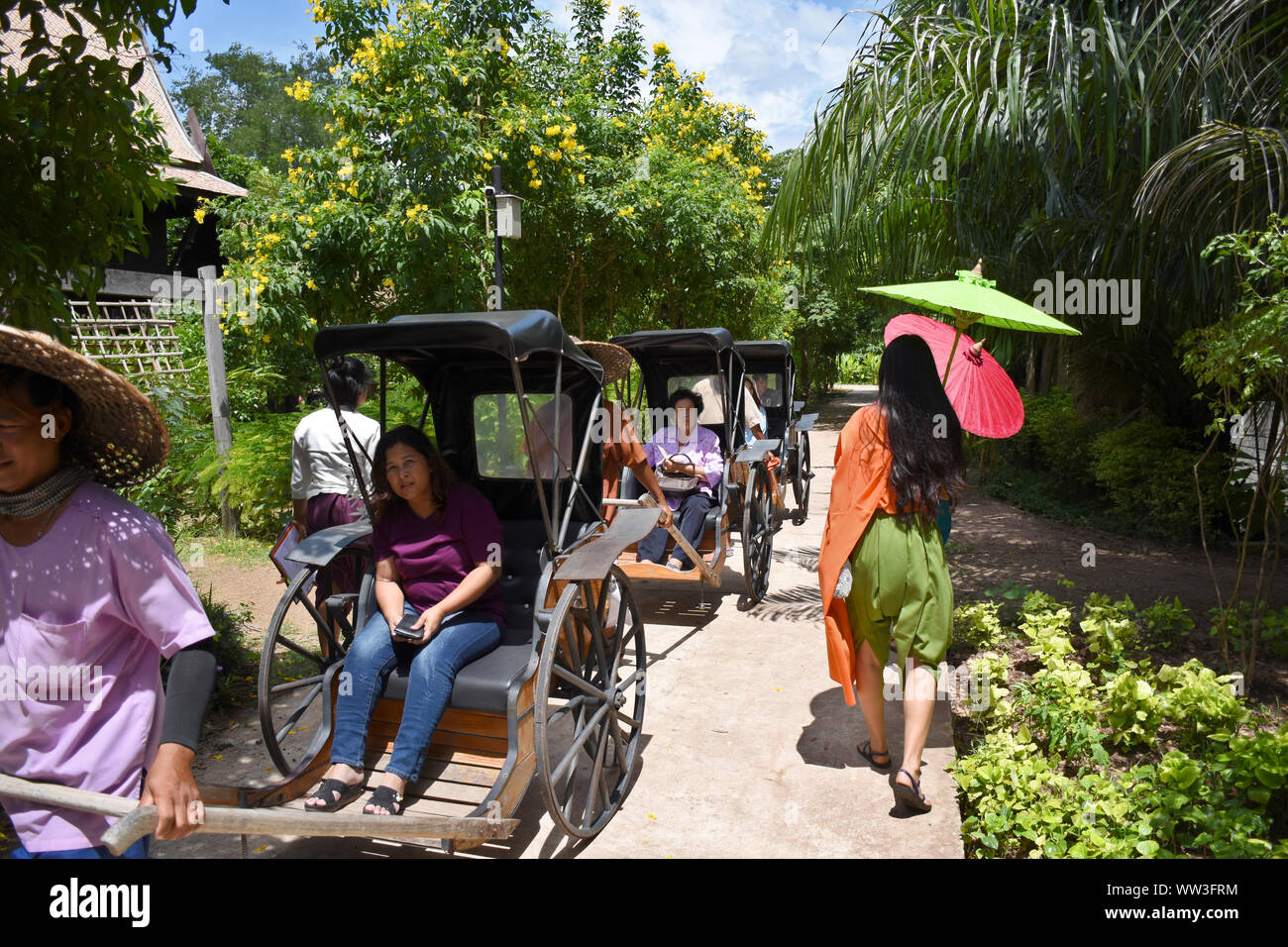 Kanchanaburi, Thailandia, 09.09.2019: locali sono il trasporto di turisti e ospiti in risciò tradizionale in 'Mallika città R.E. 124', il patrimonio, retro-ci Foto Stock