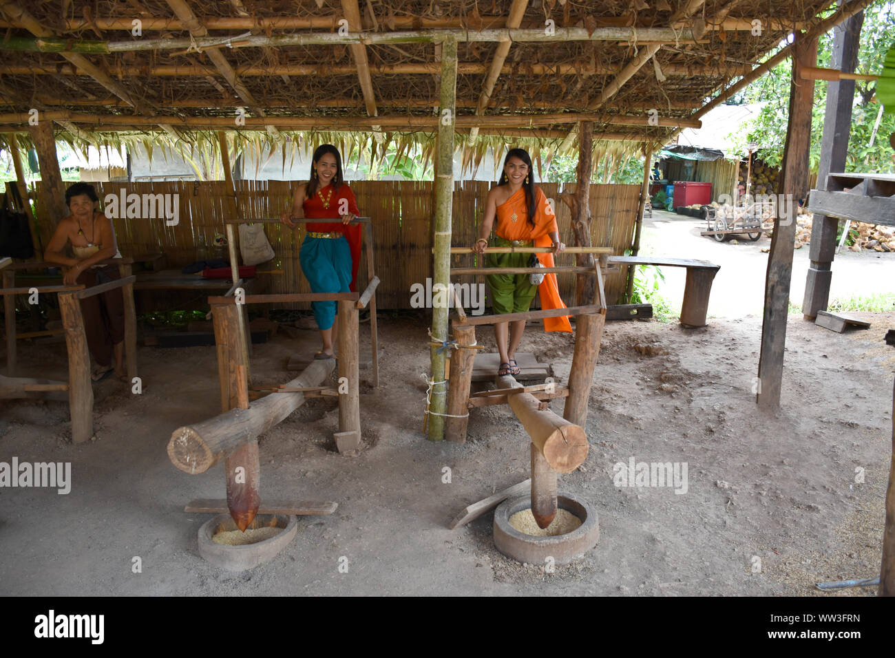 Kanchanaburi, Tailandia, 09.09.2019: due belle ragazze Thailandese in stile tradizionale Tailandese, Siamesi sono vestito pounding riso con le loro gambe in un antico e tradizionale Foto Stock