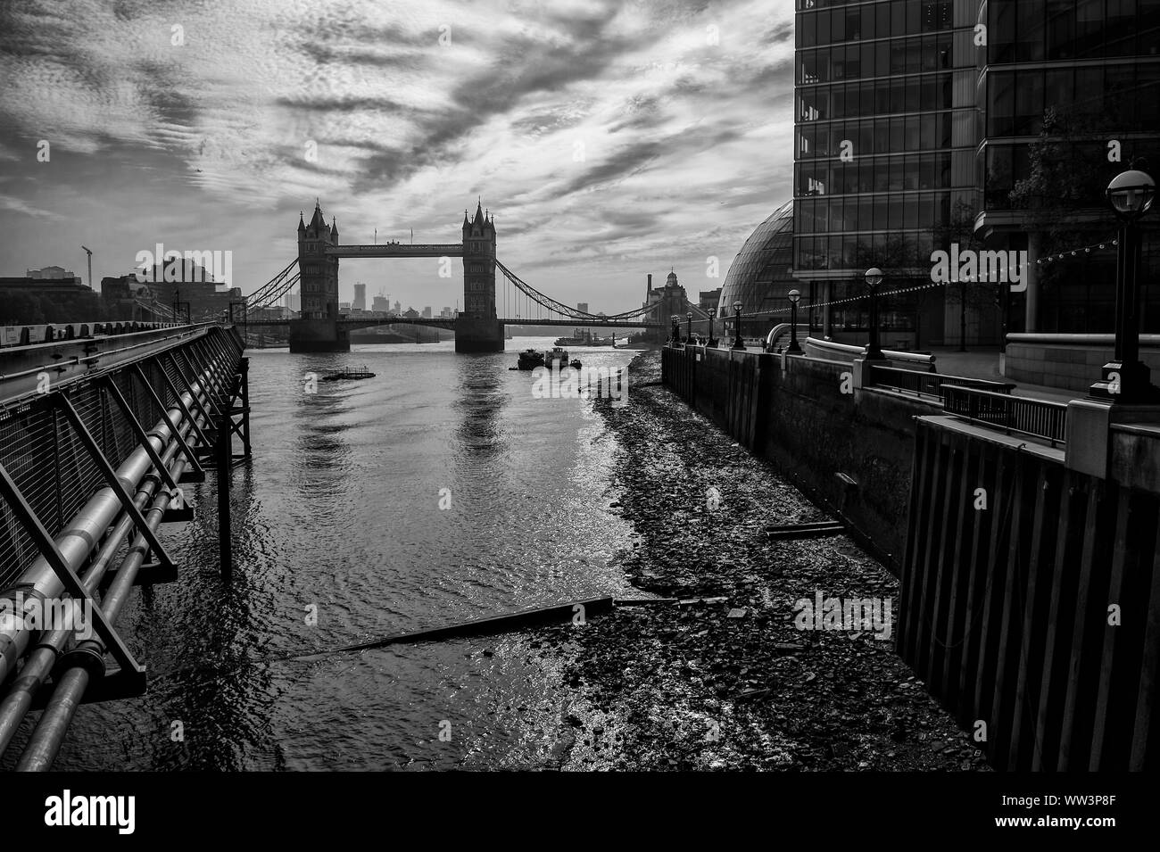 Classic silhouette monocromatiche vista del Tower Bridge da Banca del sud del fiume Tamigi su una bassa marea mattina in London, England, Regno Unito Foto Stock