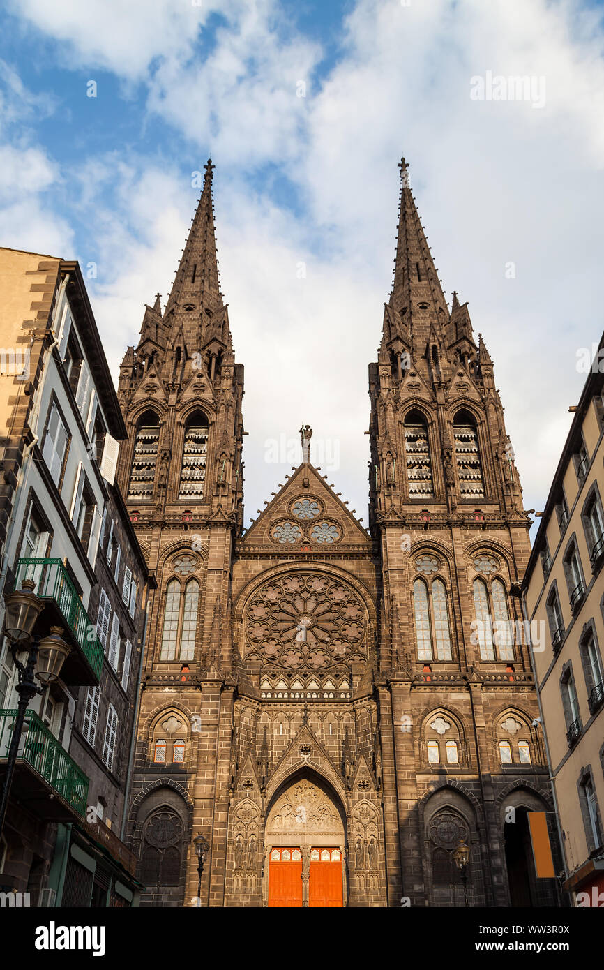 Bella e imponente cattedrale di Clermont Ferrand in Francia, realizzato da scure rocce vulcaniche alleggerire dal tramonto dorato della luce del sole Foto Stock