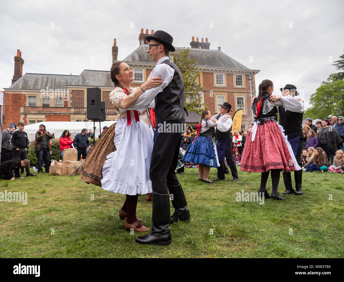 Coppie in tradizionali bulgare costumi popolari balli presso un festival bulgaro a quaranta Hall, Enfield, London, Regno Unito Foto Stock