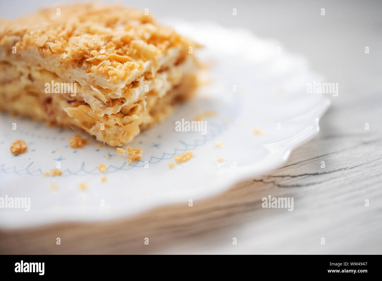 Torta Napoleone con vaniglia e crema di latte su una piastra isolata su sfondo bianco Foto Stock
