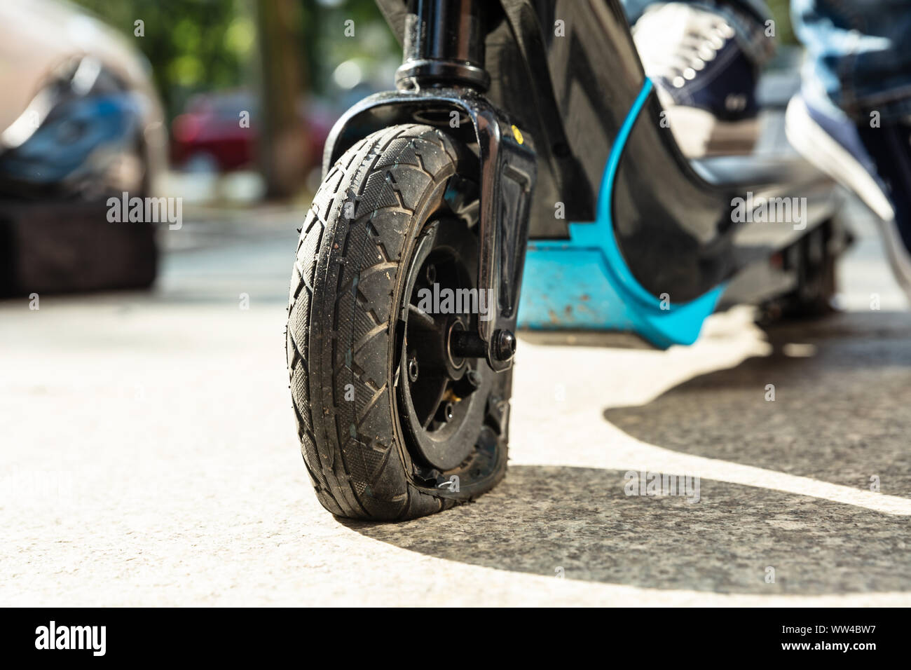 Uomo con pneumatico sgonfio sulla sua E-scooter Foto Stock