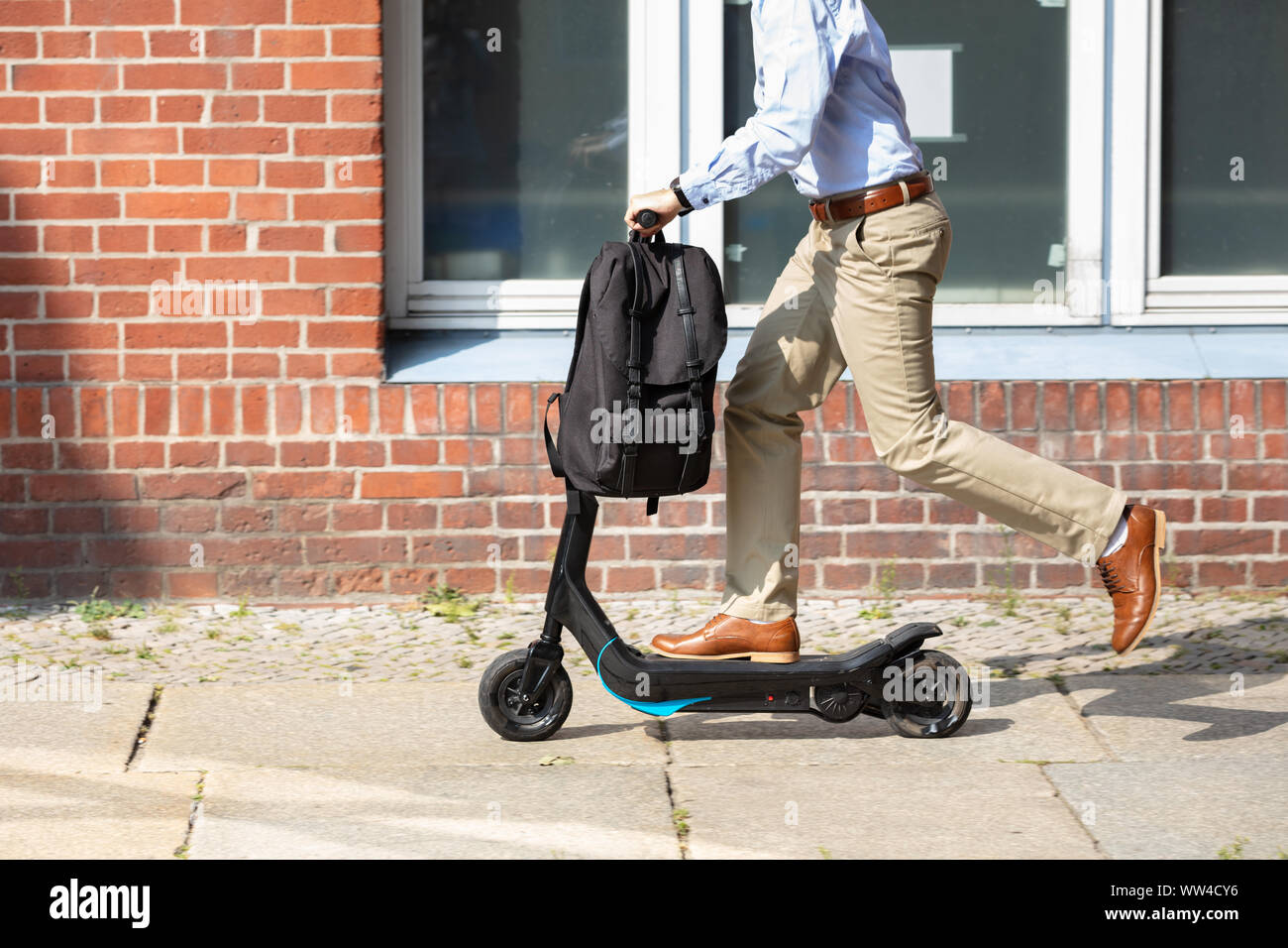 Giovane uomo che cavalca un elettrico Kick Scooter Foto Stock