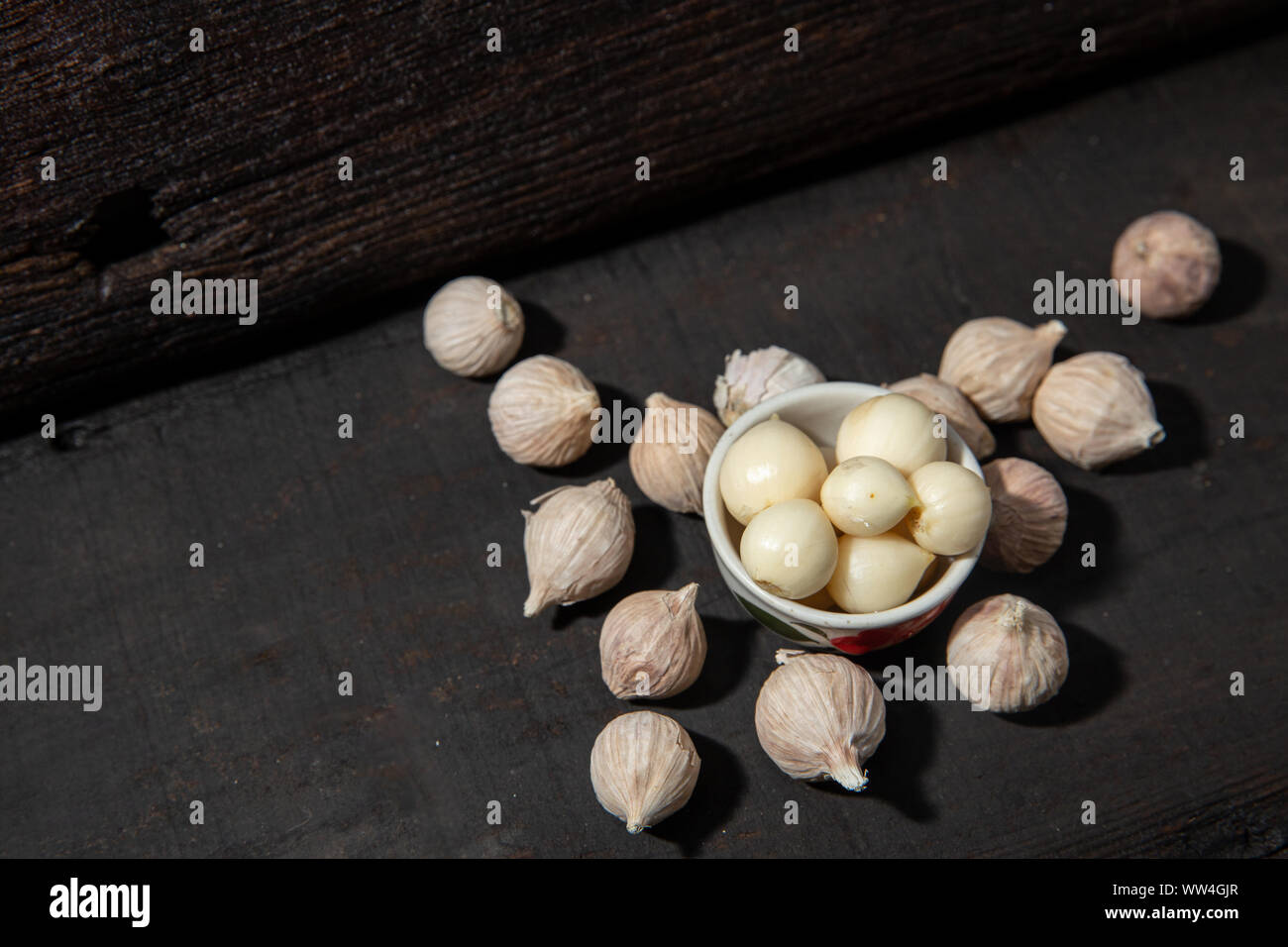 Elephant aglio lampadina singola forma sana aroma di erbe ingrediente alimentare nero su uno sfondo di legno Foto Stock