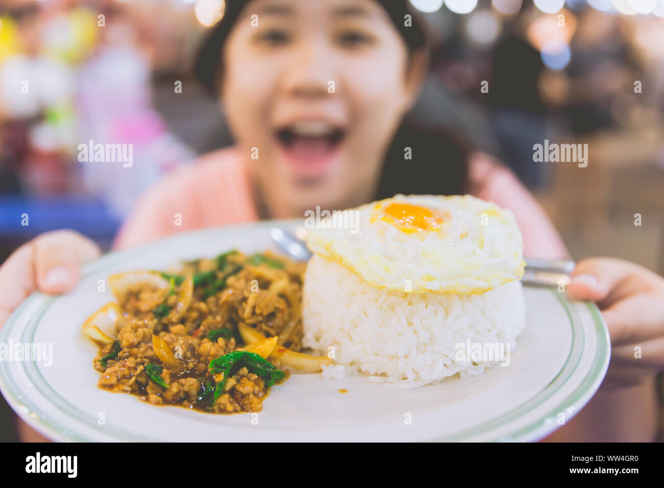 Thai street food Pad Kaprow Moo Kai Dow saporito e gustoso presente da Thai Cute girl teen Foto Stock