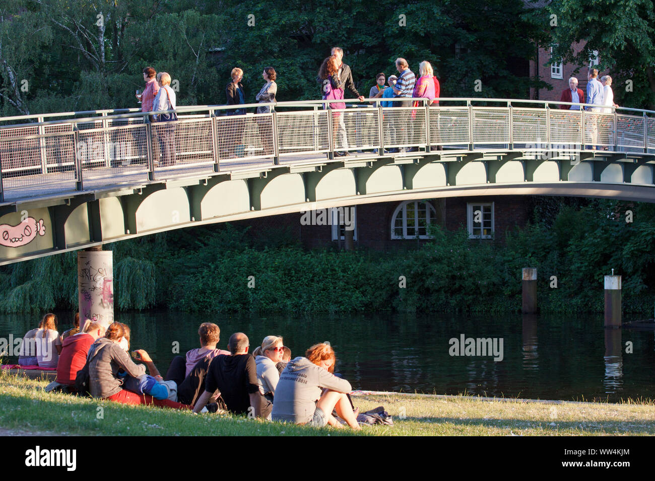 I giovani seduti sulla riva dell'Alster in Winterhuder Kai. District Eppendorf. Foto Stock