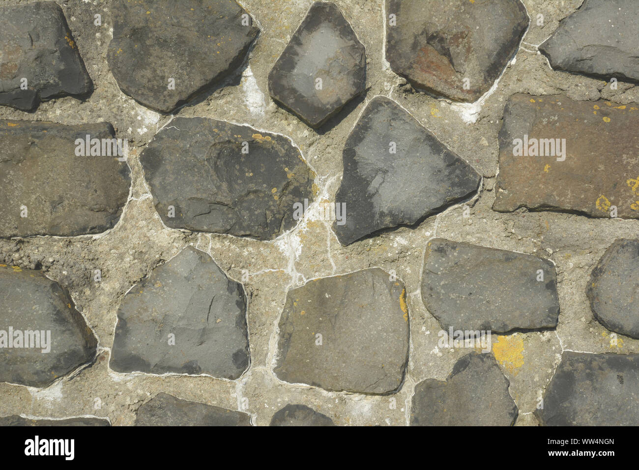 Sfondo con parete irregolare con il grigio e marrone irregolare di dimensioni differenti e pietre sagomate in calcestruzzo Foto Stock