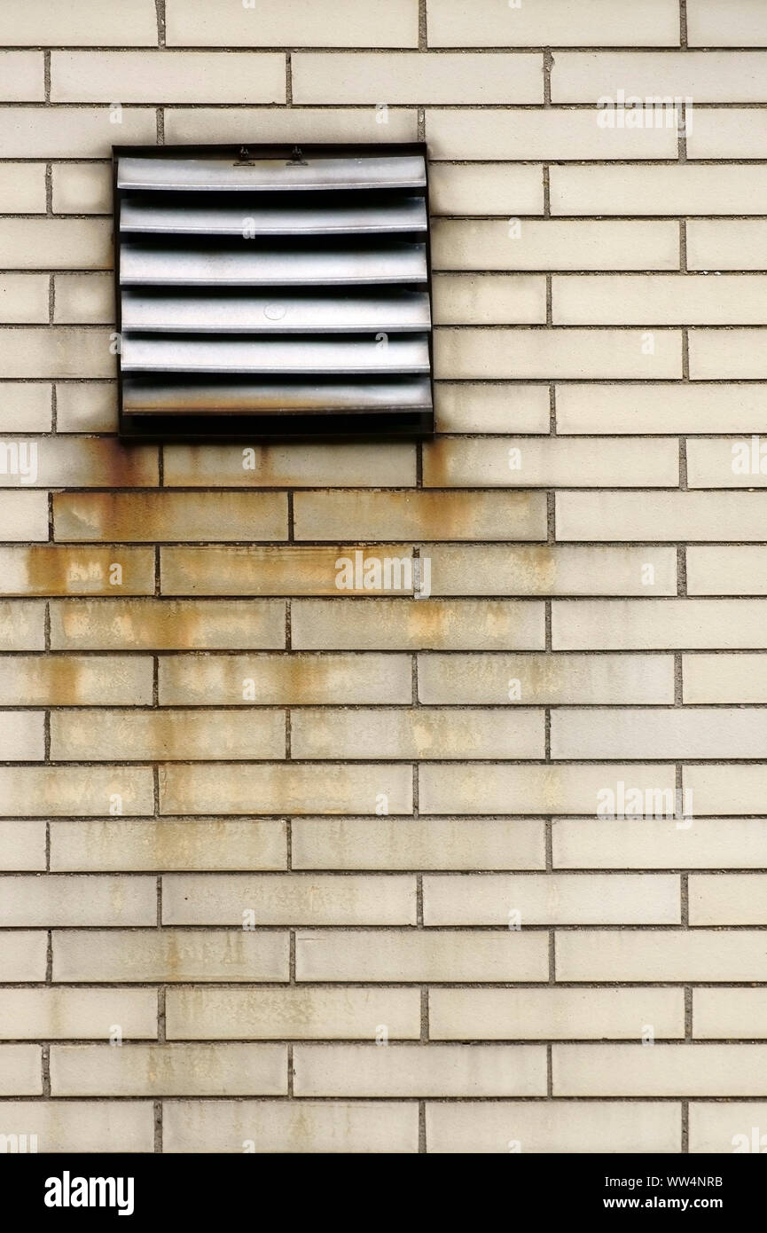 La fotografia di una griglia di aerazione su una parete dal sorprendente e rusty mattoni, Foto Stock