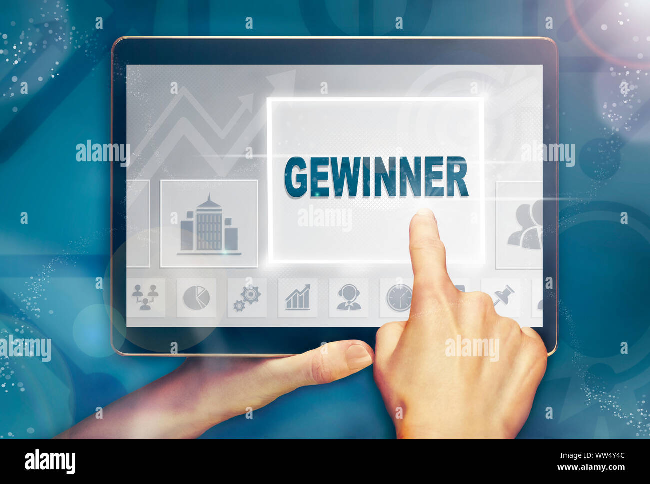 Una mano holiding Un computer tablet e premendo un vincitore "Gewinner' concetto aziendale. Foto Stock