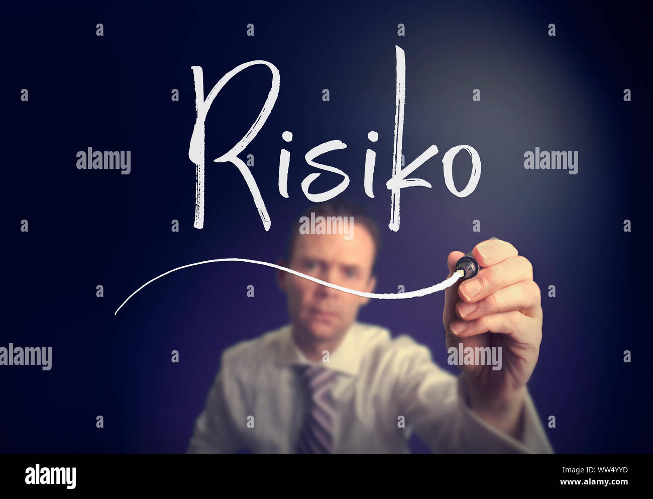 Un imprenditore iscritto un rischio "Risiko' concetto in tedesco con una penna bianca su uno schermo chiaro. Foto Stock