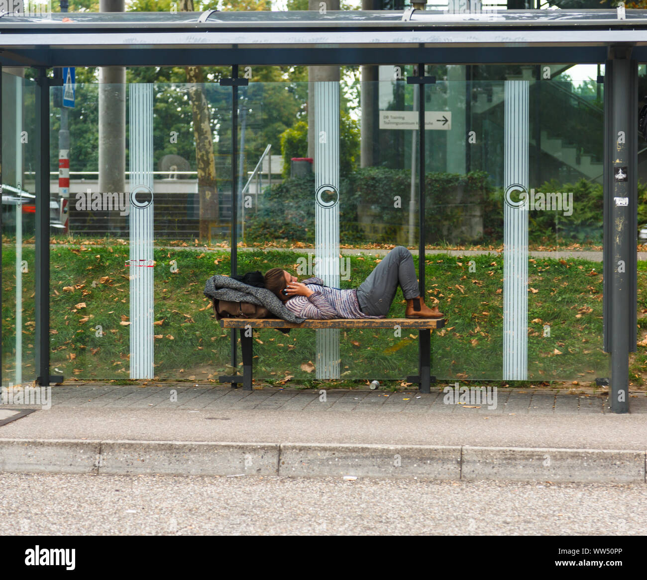 Un uomo si trova su una panchina nella strada Foto Stock