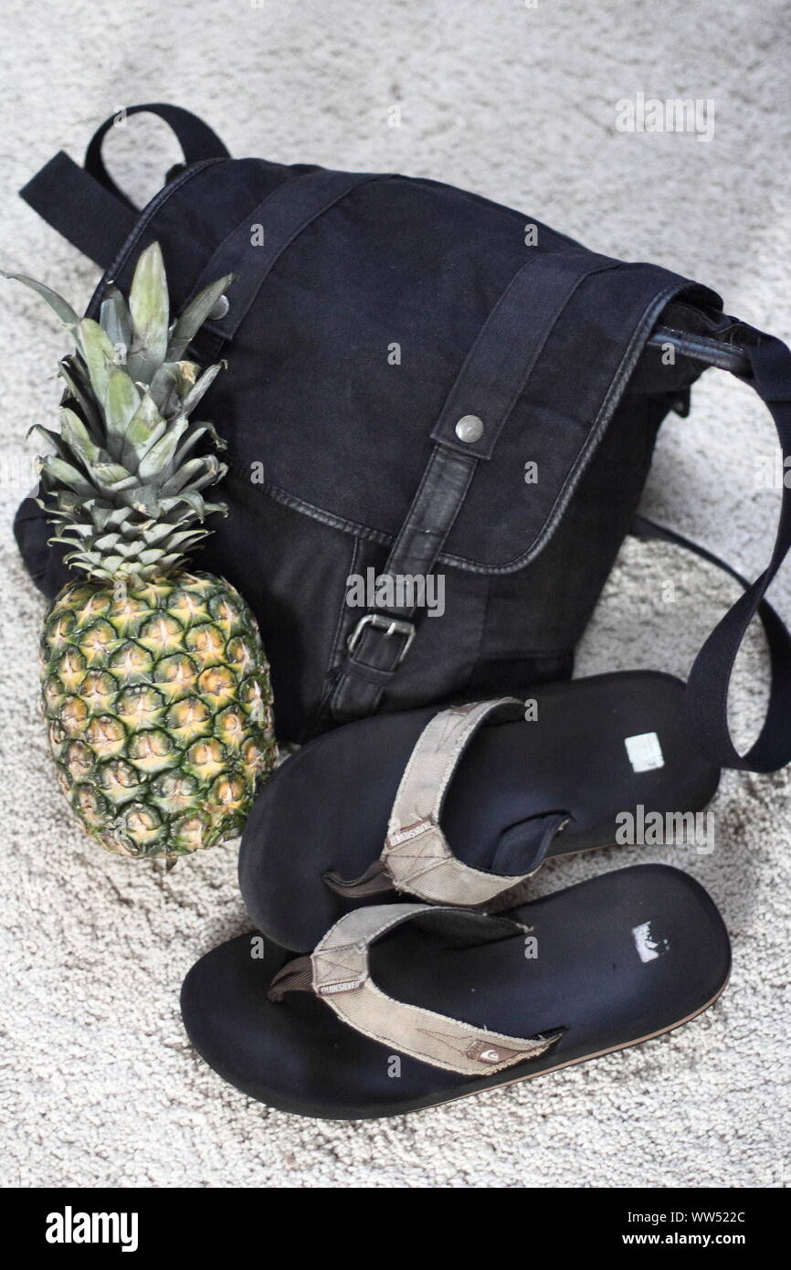 Borsa a tracolla, flip-flop e un ananas per la giornata sulla spiaggia o presso la piscina, Foto Stock
