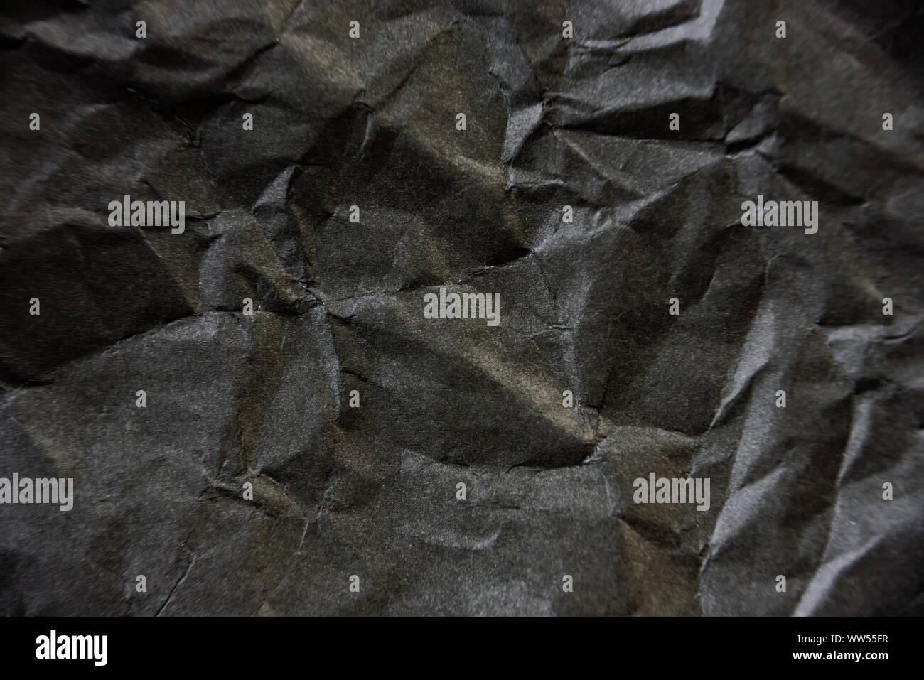 Crumpled carta nera texture. Il contrasto dello sfondo astratto Foto Stock
