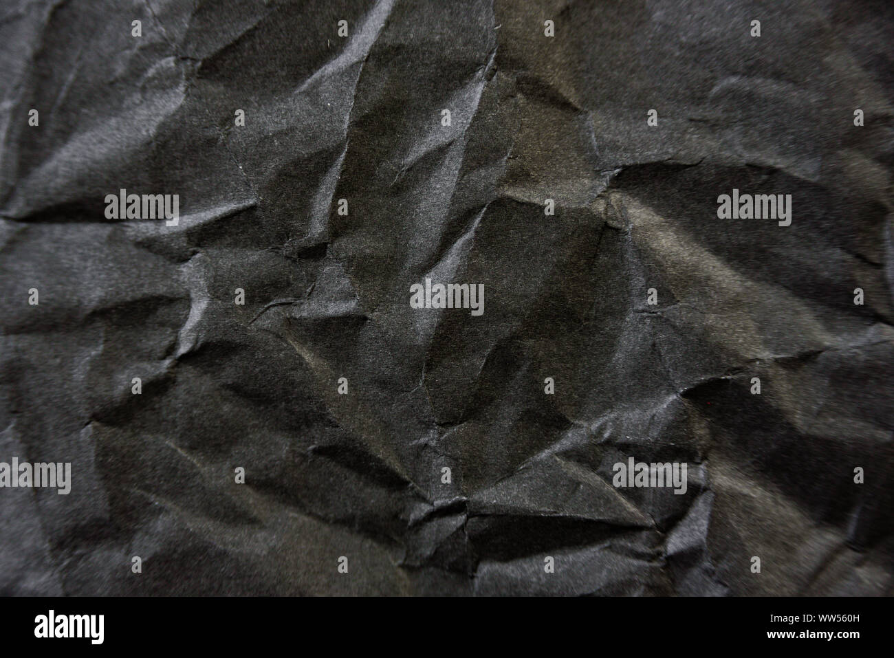 Crumpled carta nera texture. Il contrasto dello sfondo astratto Foto Stock