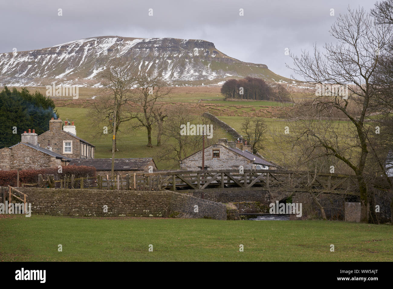 Viste di Pen-y-Ghent con neve invernale con Horton in Ribblesdale in primo piano. Foto Stock