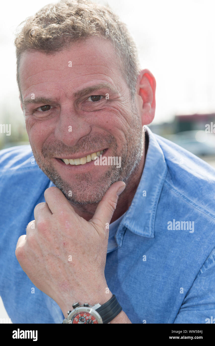 L'uomo, mano sul mento, esterno Foto Stock