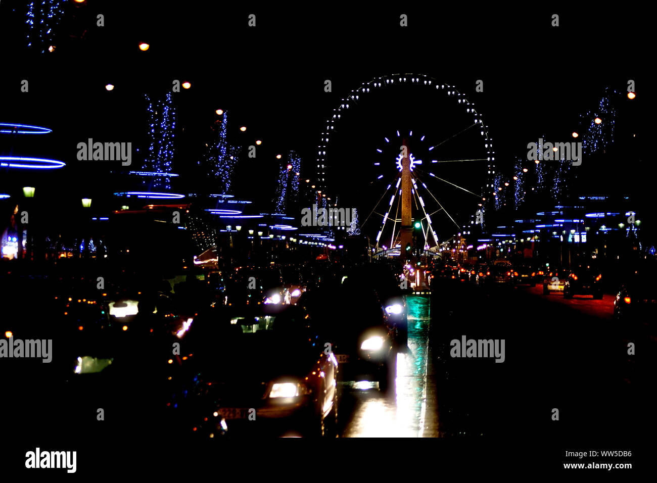 Il Christmassy decorate Champs Elysee di notte con il traffico e la ruota panoramica Ferris a Parigi, Foto Stock