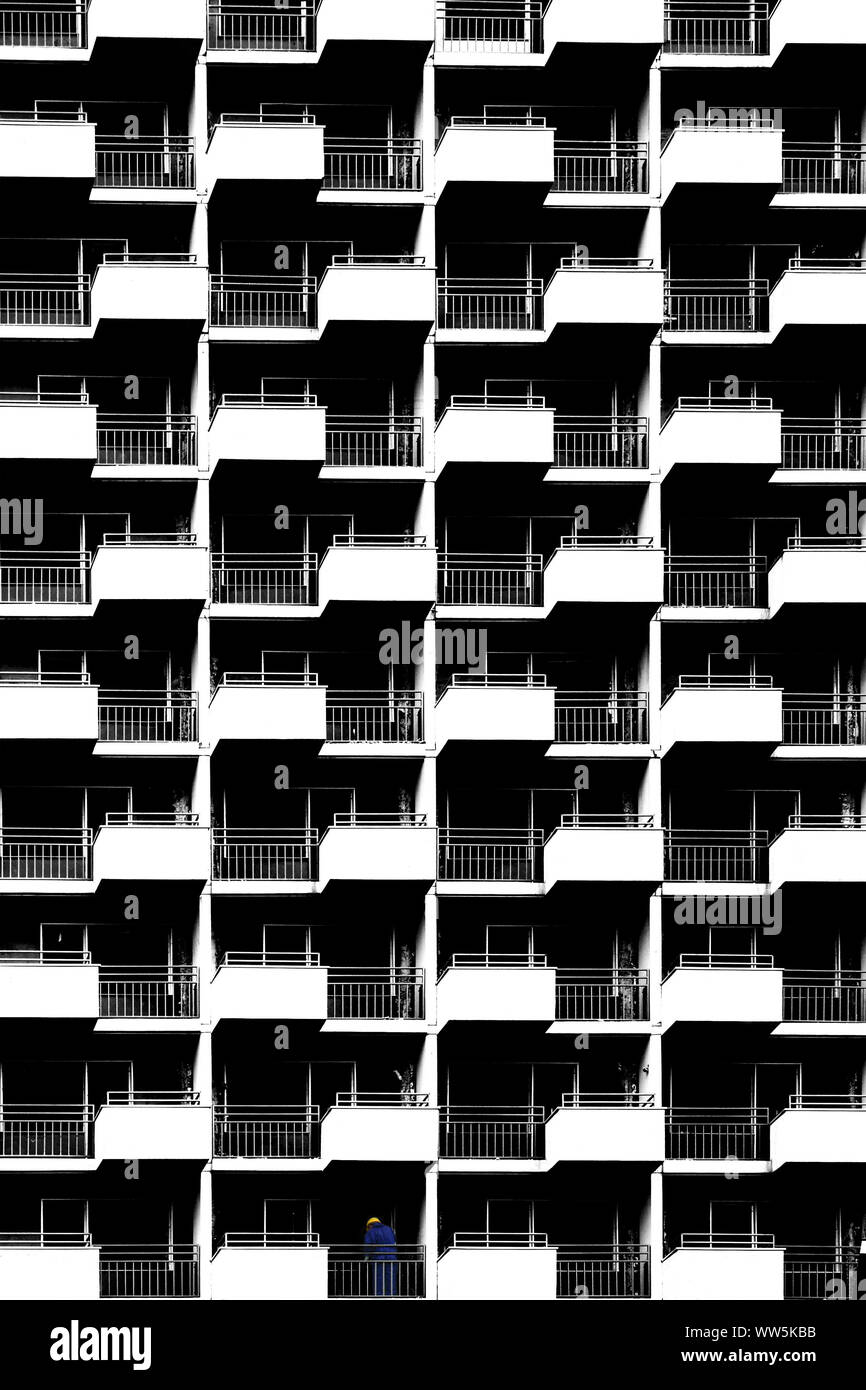 La fotografia della facciata di un alto edificio con lavoratore edile sul primo piano, Foto Stock