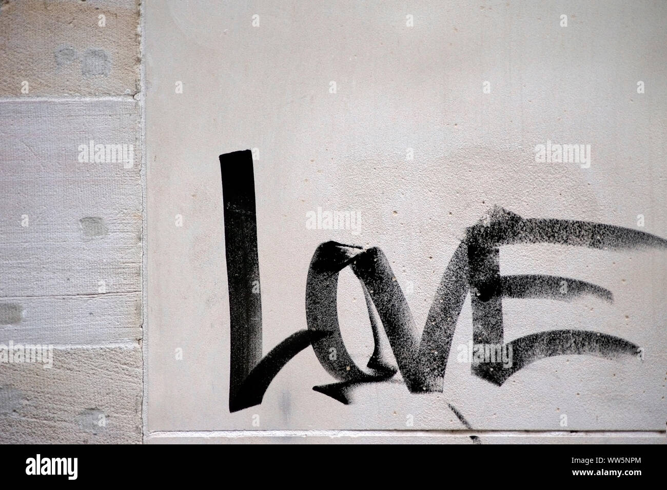La fotografia della parola amore dipinta con un pennello sul muro di una casa, Foto Stock