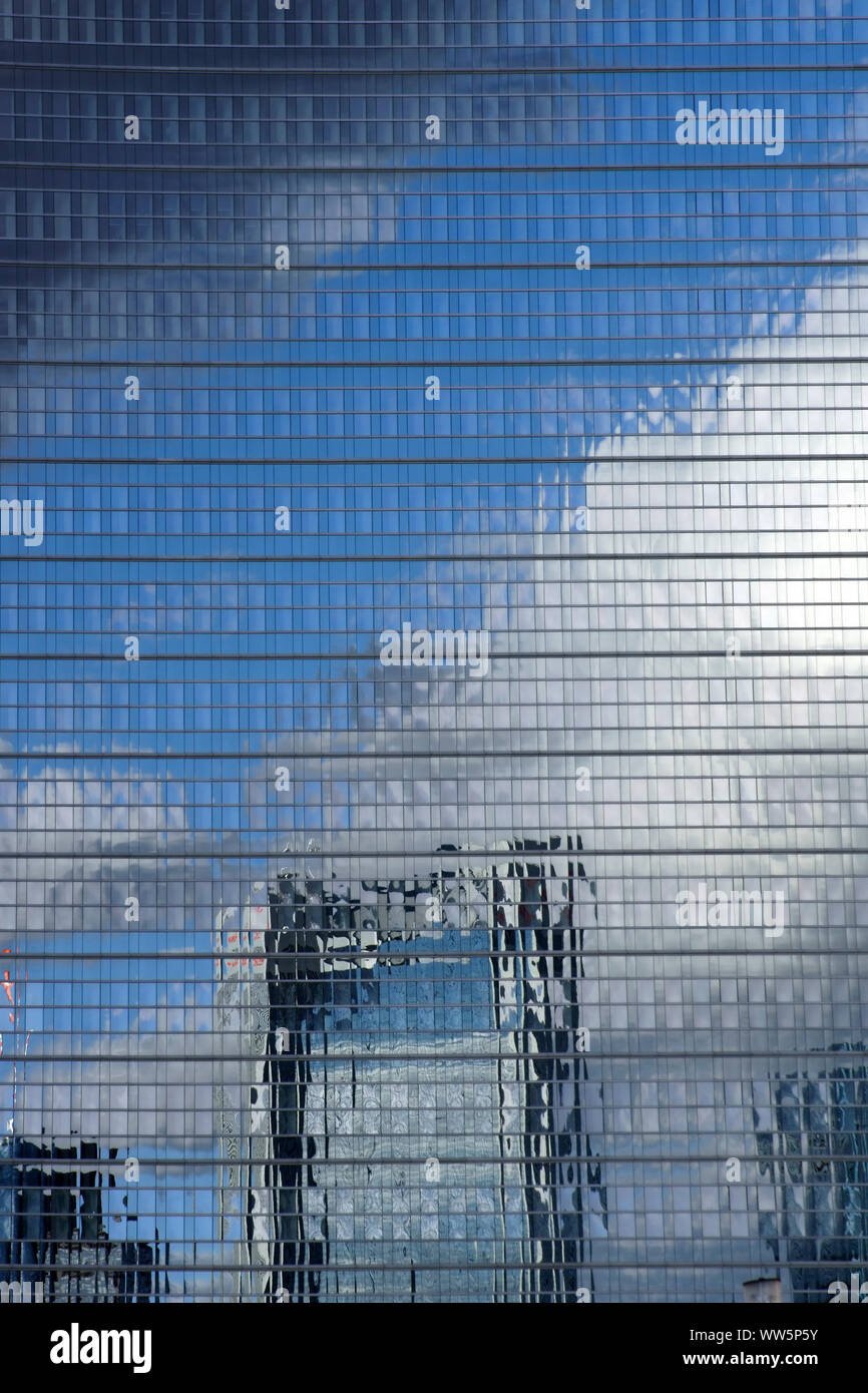 La fotografia di un abstract alto della facciata con la riflessione di una skyline e nuvole, Foto Stock