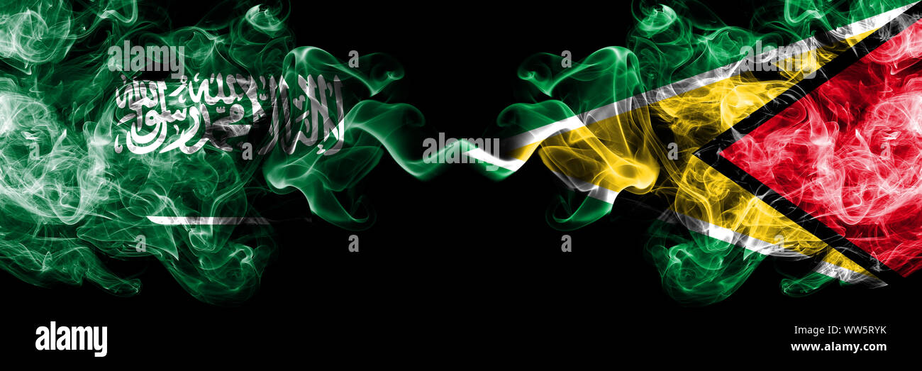 Arabia Saudita Regno vs Guyana, Guyanese smoky mystic bandiere poste fianco a fianco. Spessa colorata fumo setosa bandiere di arabo, Araba e la Guyana, Guyane Foto Stock