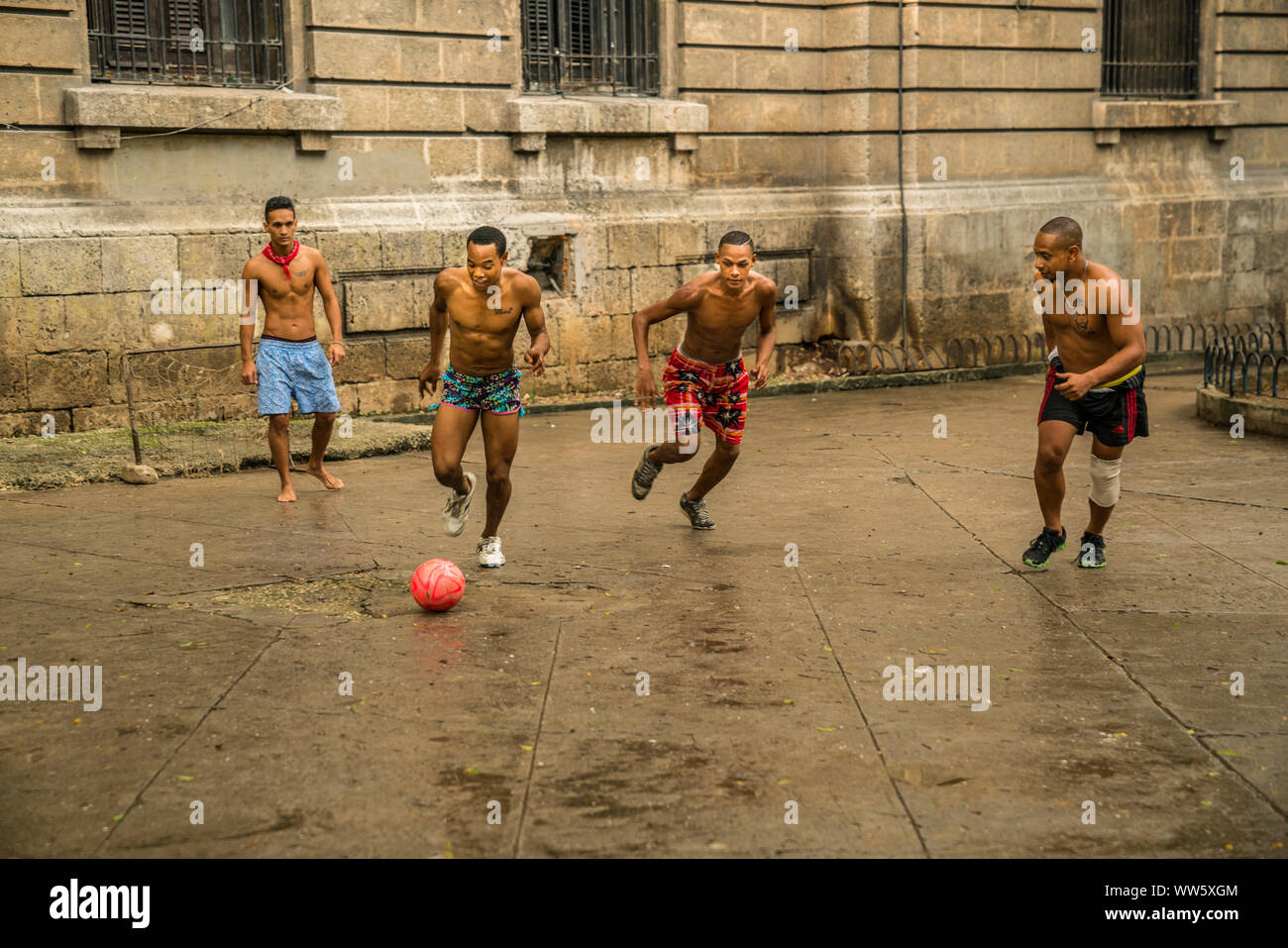 Giovani uomini che giocano a calcio per strada, Havana, Cuba Foto Stock