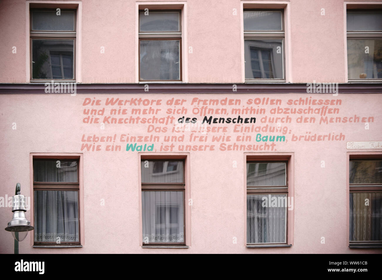 Un slogan politici dipinta a una facciata di un edificio residenziale e vecchio edificio di Berlino Kreuzberg, Foto Stock