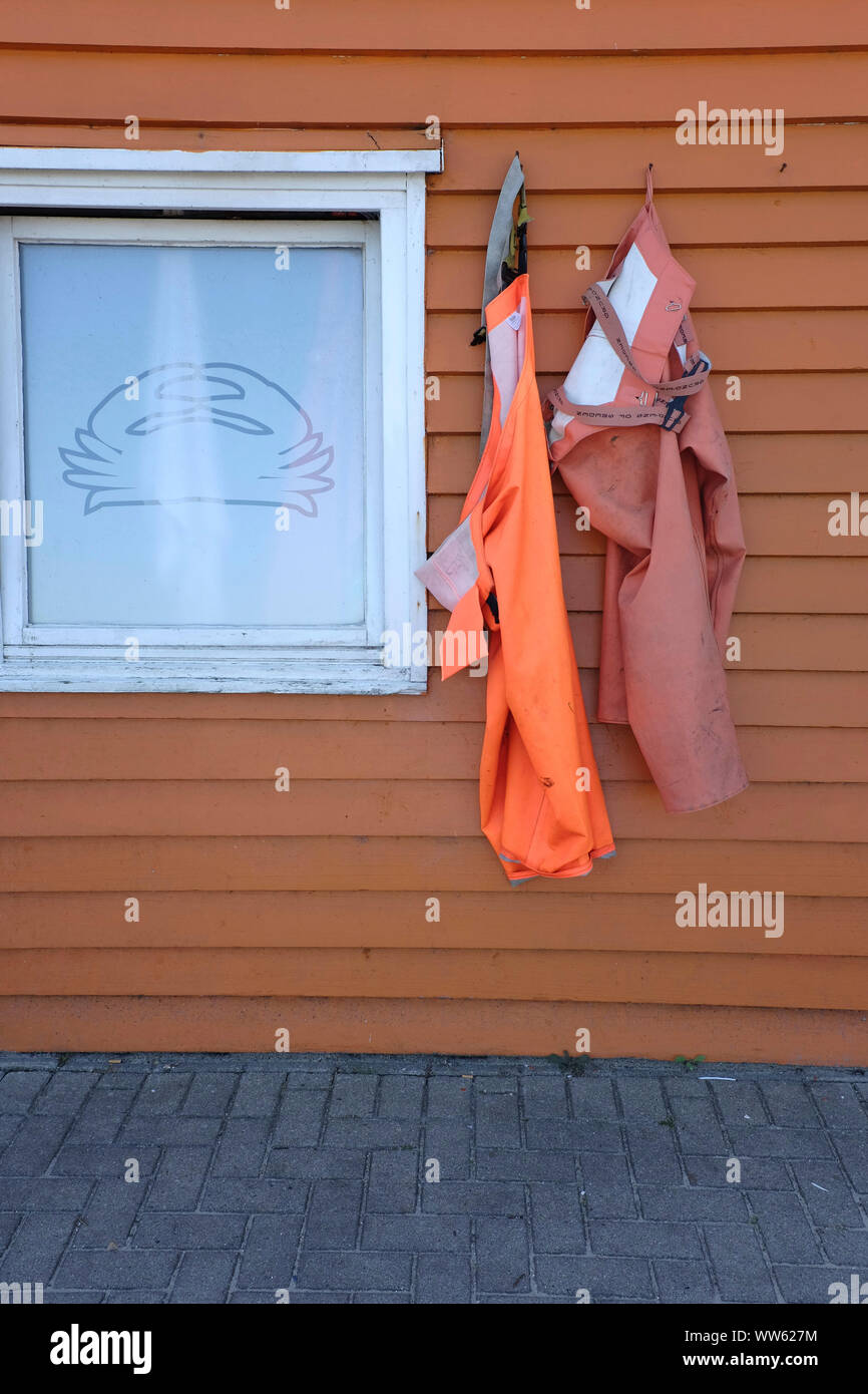 Pescatore di gamberi sull isola di Helgoland, vestiti appesi sulla parete in legno Foto Stock