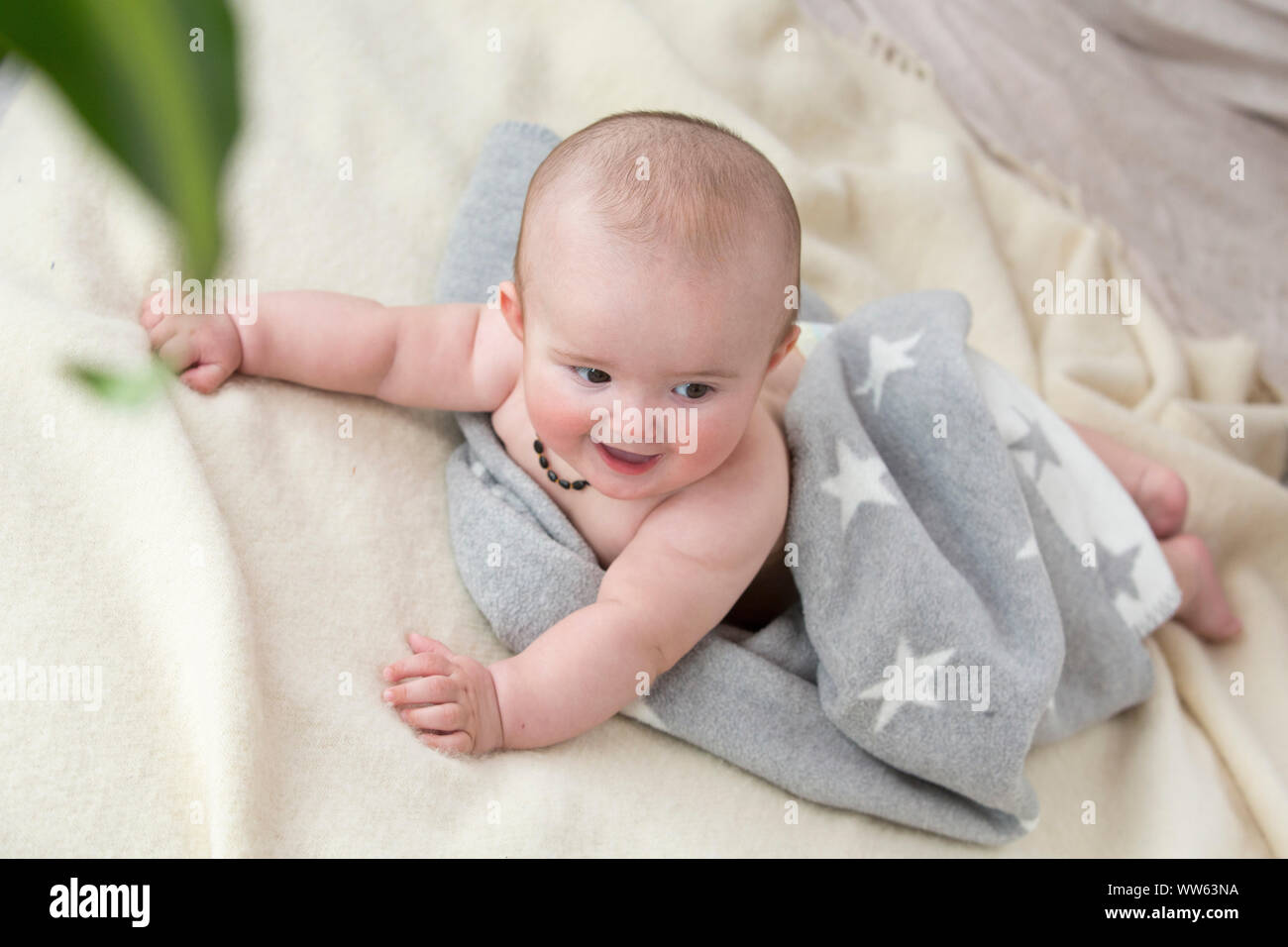 Bambino è sdraiato prono su una coperta Foto Stock