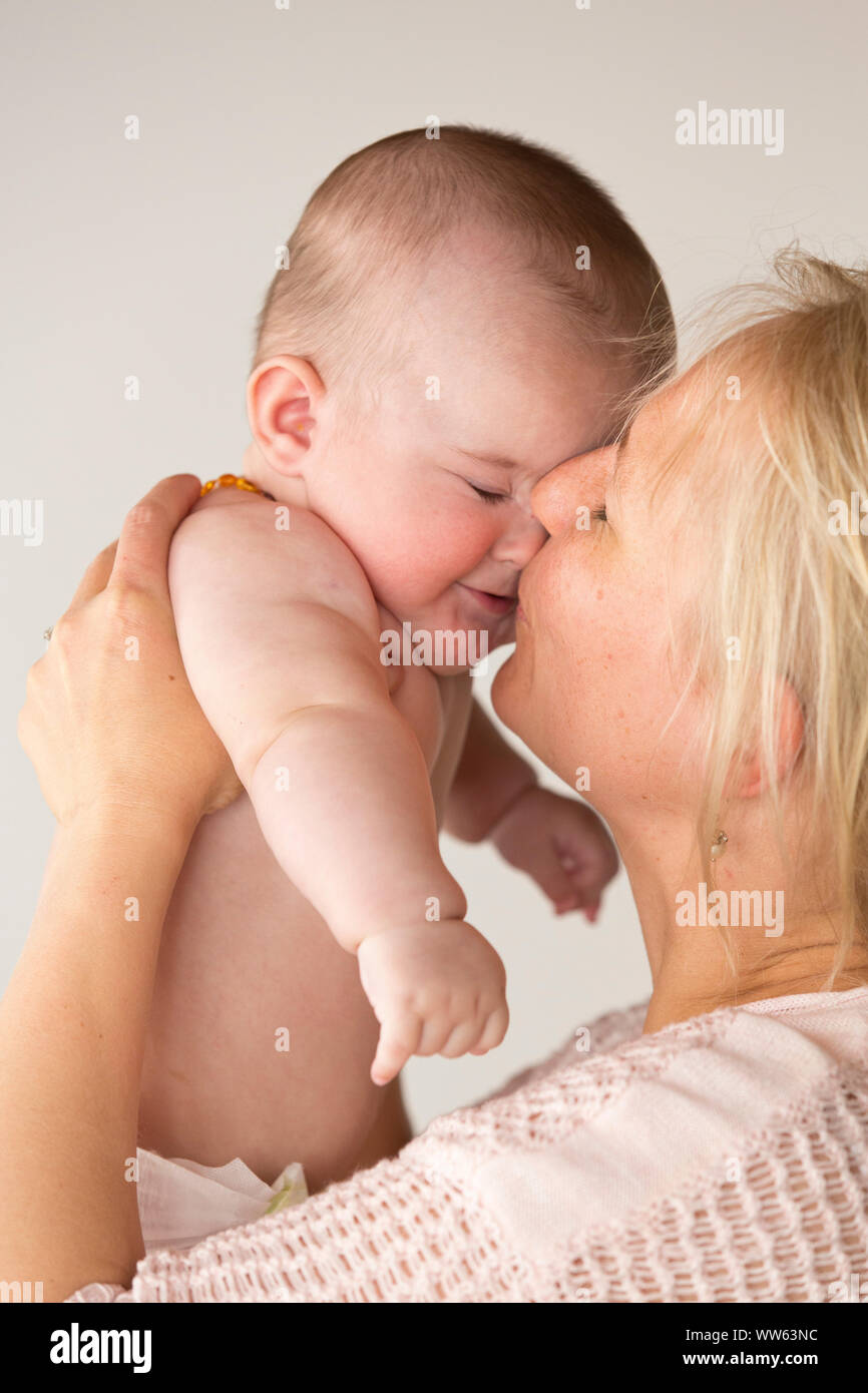 Madre solleva baby fino a kiss, ritratto Foto Stock