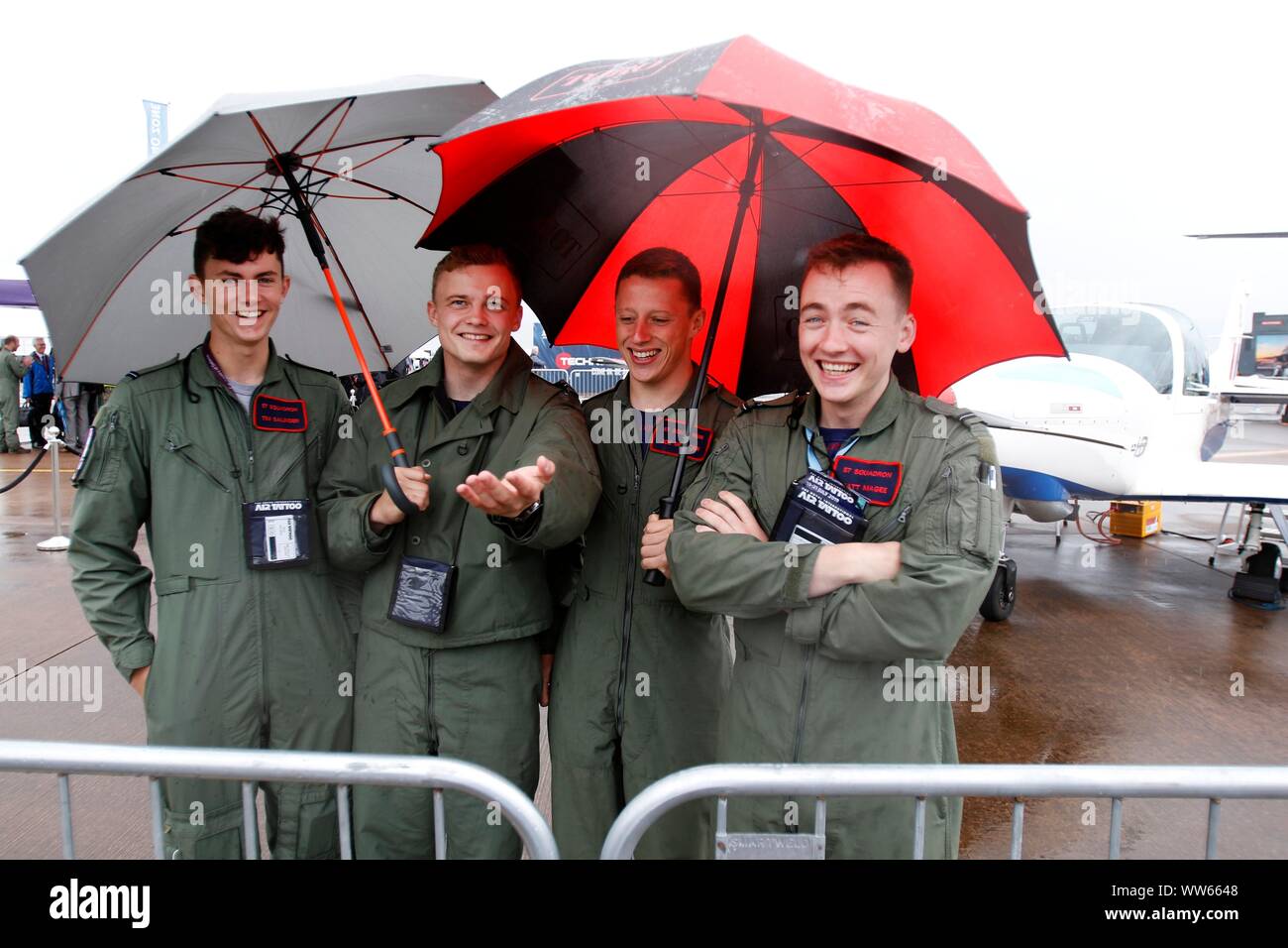 Partecipante piloti di 57 Squadriglia con base a RAF Cranwell mantenere asciutta con uno di loro Prefetto della formazione su aeromobili mostrano. Pioggia, bassa base cloud e alta vincere Foto Stock