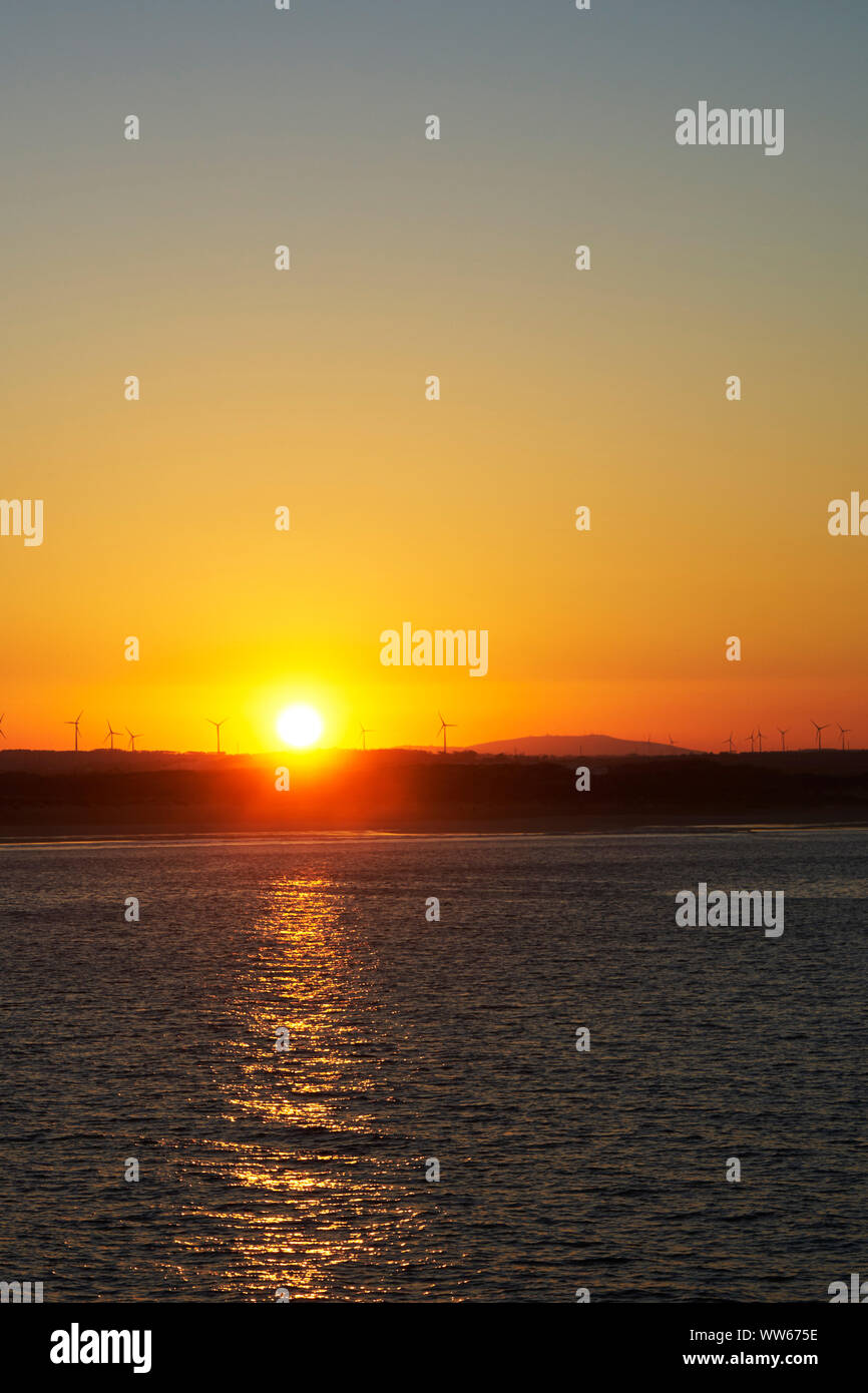 Le turbine eoliche all'alba sulla collina al mare Foto Stock