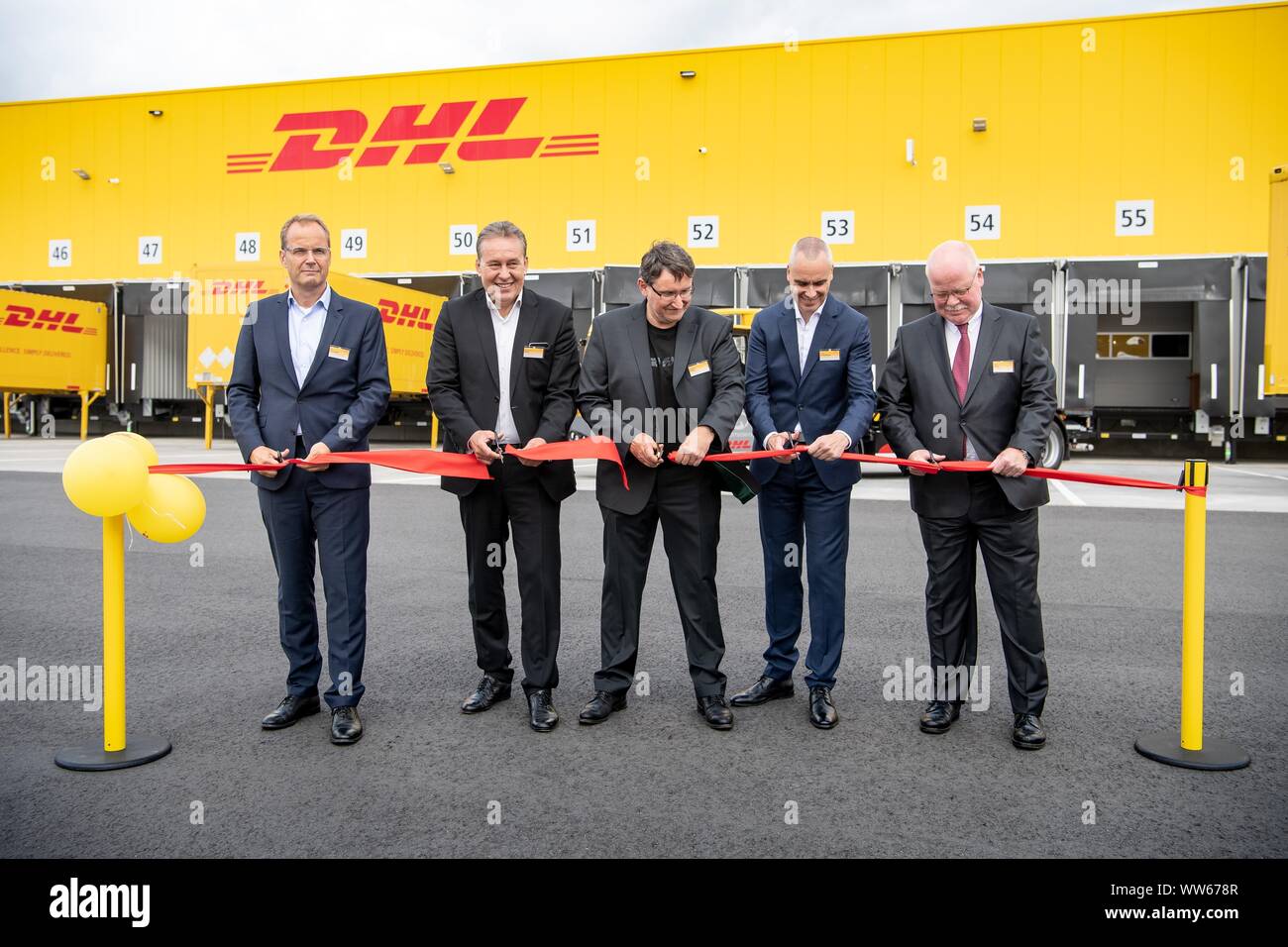 Langenhagen, Germania. Xiii Sep, 2019. Tim Scharwath (l-r), DHL, membro del consiglio di amministrazione, Bernhard Wirth, DHL, membro del consiglio di amministrazione, Hartmut Köhler, direttore di filiale DHL Freight Hannover, Gero Schiffelmann, Managing Director DHL Freight e Uwe Brinks, DHL, membro del consiglio di amministrazione, aprire la nuova DHL Freight terminal con un taglio simbolico attraverso un nastro rosso. Credito: Sina Schuldt/dpa/Alamy Live News Foto Stock