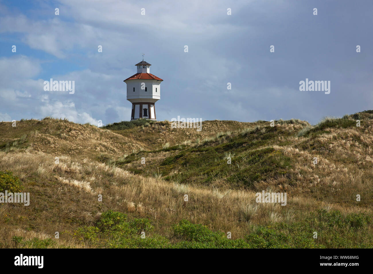 Vista al di sopra delle dune per la vecchia torre di acqua, il punto di riferimento dell'isola Langeoog. Foto Stock