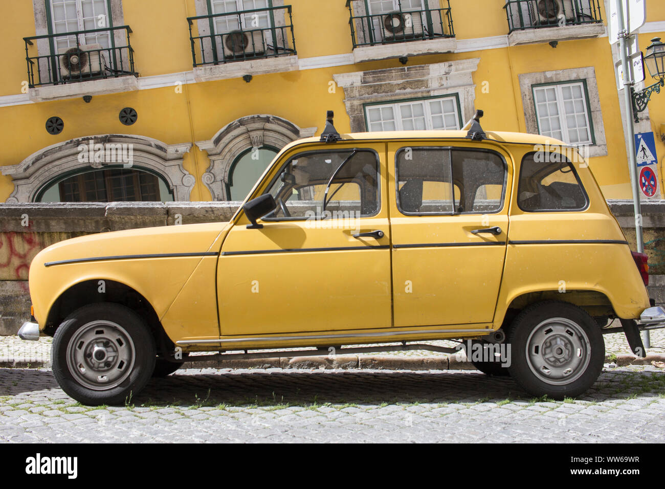 Dettaglio degli scatti da colorate strade di Lisbona, giallo auto davanti casa gialla parete. Foto Stock