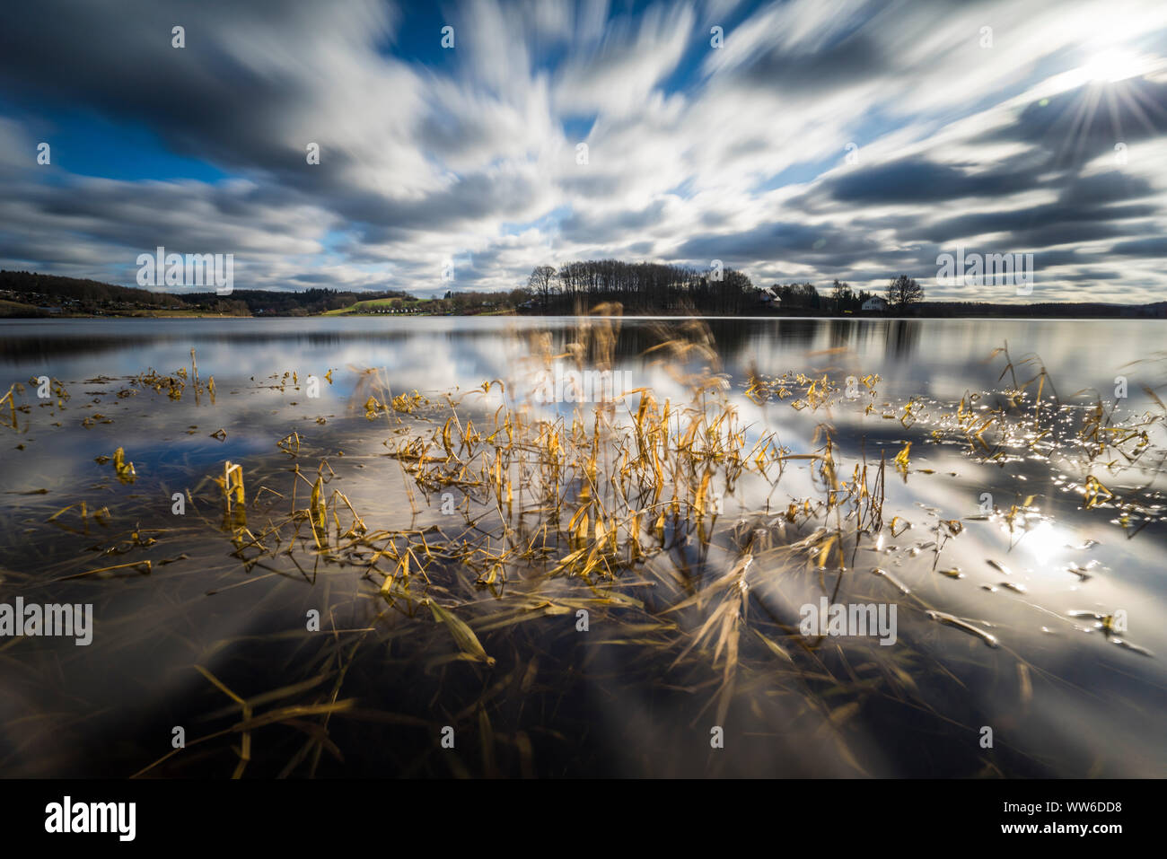 Tramonto sul lago in inverno con la deriva nuvole Foto Stock