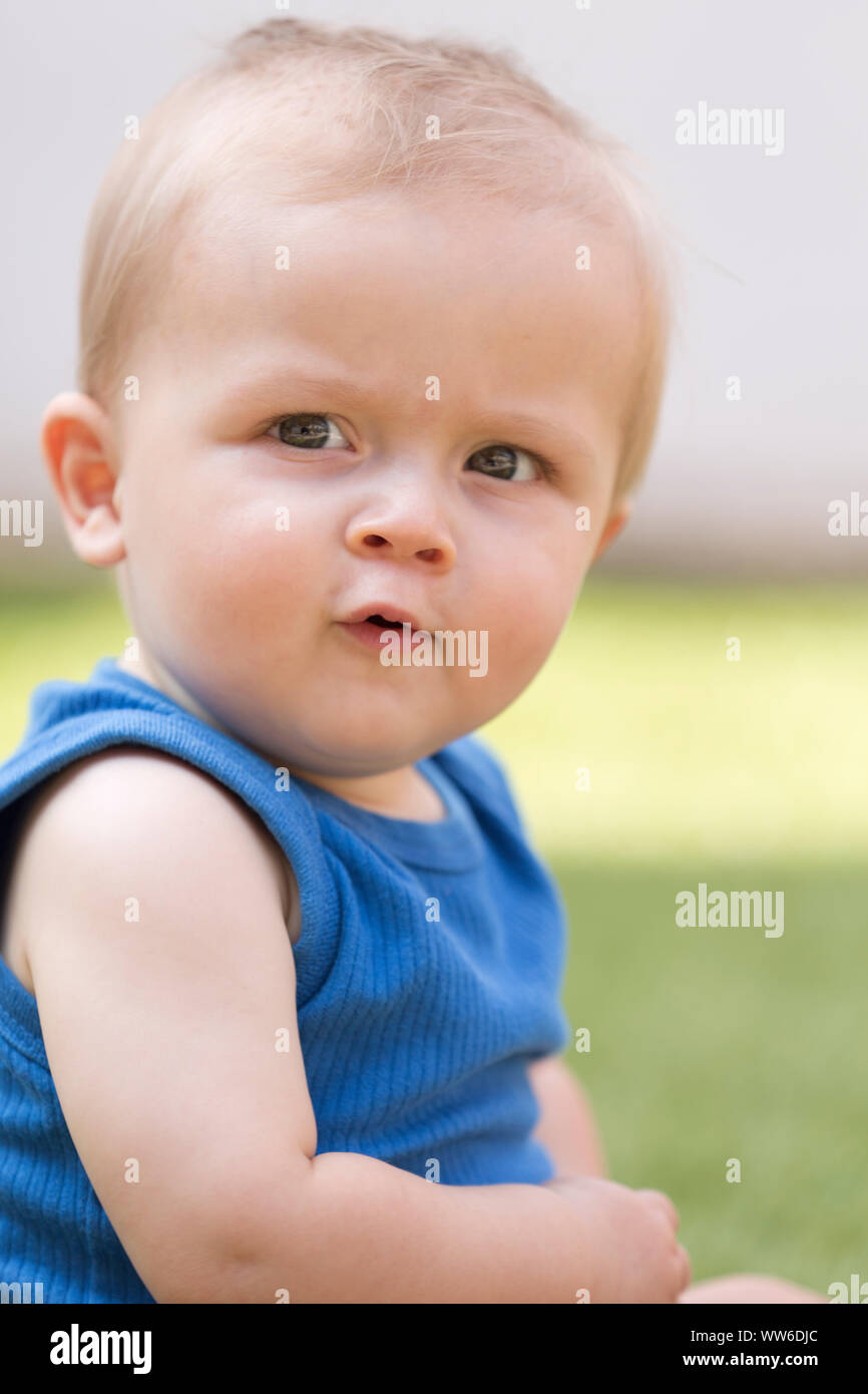 Il bambino è seduto in erba, ritratto Foto Stock