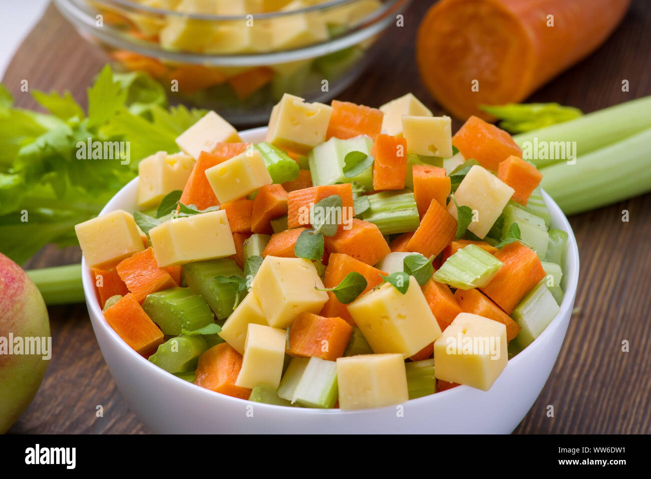 Vitamina insalata di sedano, carote, mele e formaggio. Insalata di verdure con formaggio tagliato a cubetti in una piastra e un certo numero di ingredienti. Foto Stock