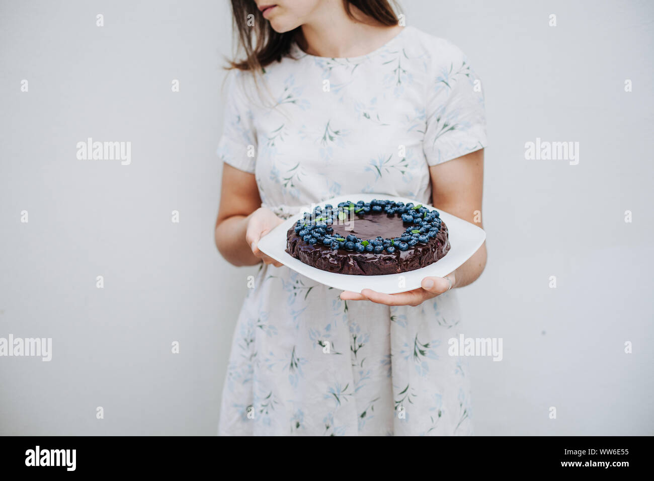 Donna che mantiene un mirtillo brownie al cioccolato torta Foto Stock