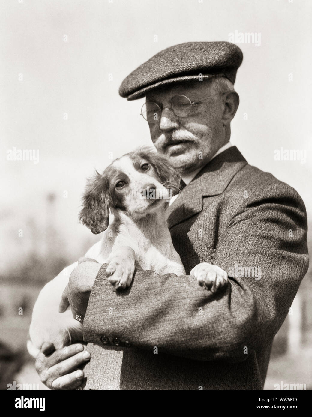 1920s'Irlandese rosso e bianco cucciolo SETTER DETENUTE IN ARMI DA SENIOR uomo baffi bianchi FILO RIM indossando occhiali TWEED HAT e rivestire - d848 HAR001 HARS TWEED rurale spazio copia di metà lunghezza persone ispirazione CARING MASCHI SENIOR uomo adulto SENIOR B&W I BAFFI tentazione indossare giacca e cravatta felicità mammiferi età antica OLDSTERS MUSTACHES e canini scelta emozione DETENUTE SETTER orgoglio da autorità dei peli del viso anziani POOCH collegamento concettuale di lana elegante attaccamento personale UPLAND FILO RIM affetto canino crescita emozione mammifero convivere in bianco e nero di etnia caucasica HAR001 IN ARMI Foto Stock